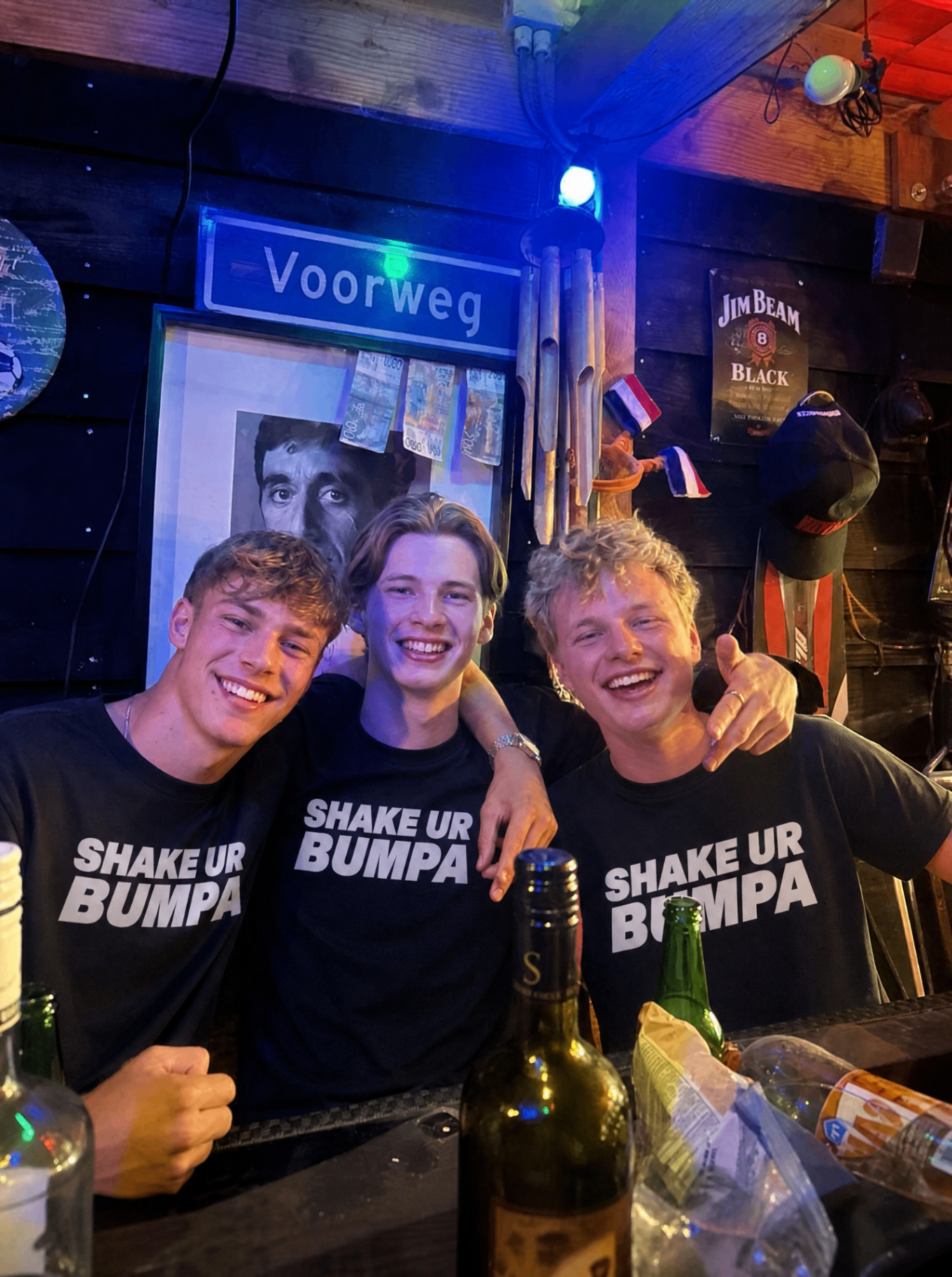 Drie vrienden in Shake Ur Bumpa shirts in een bar