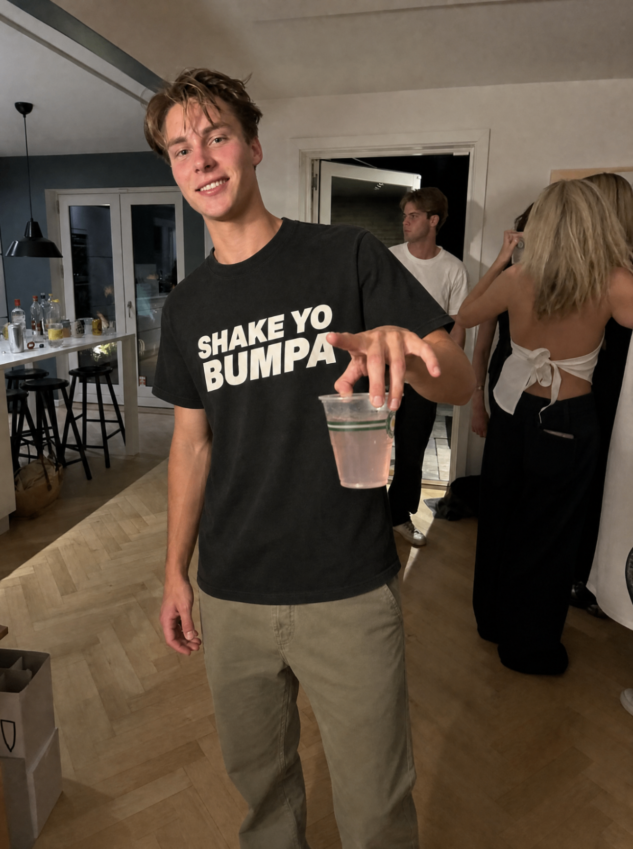 Man in Shake Ur Bumpa shirt op een huisfeest