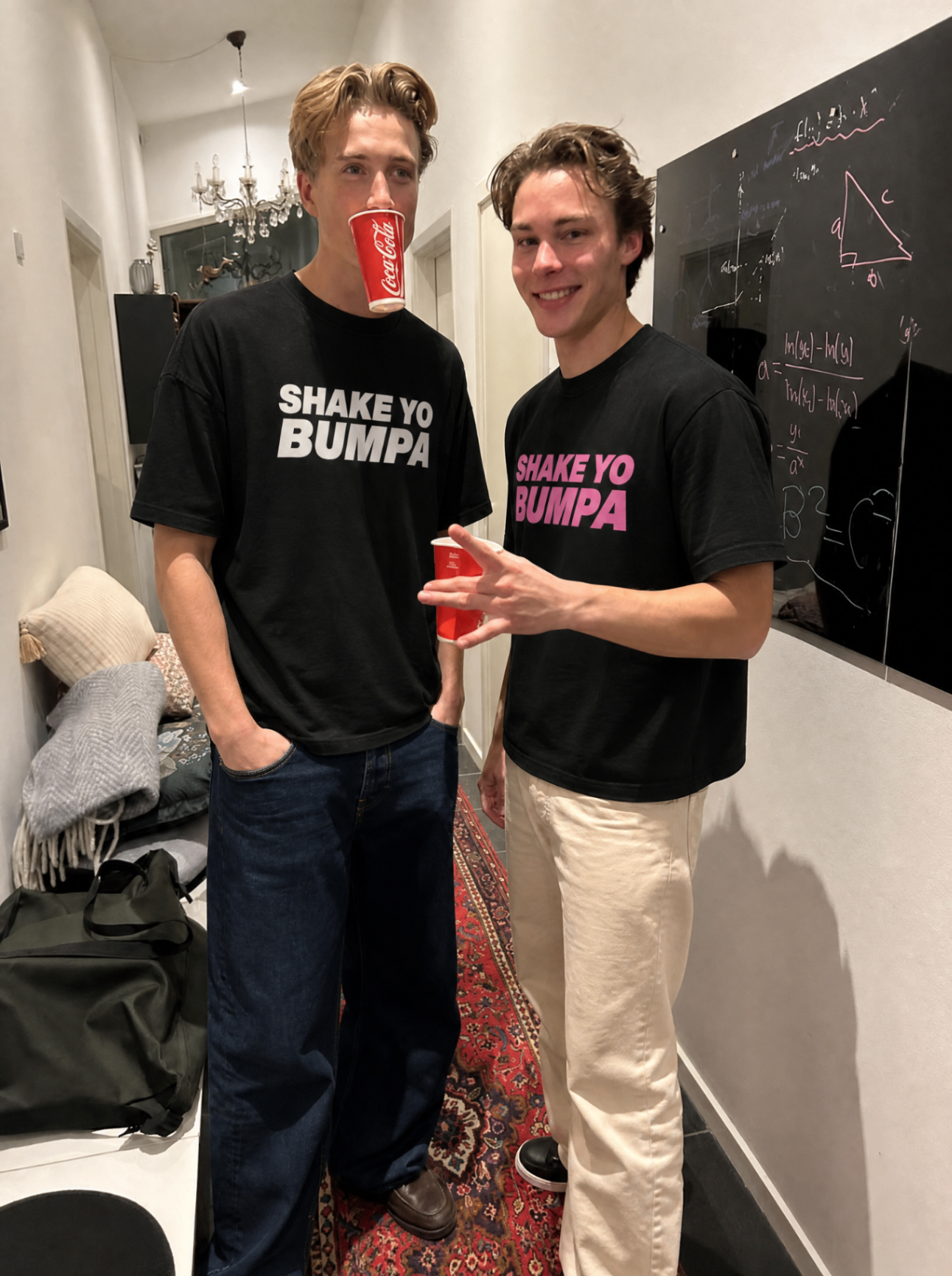 Twee mannen in Shake Ur Bumpa shirts op een feestje binnen