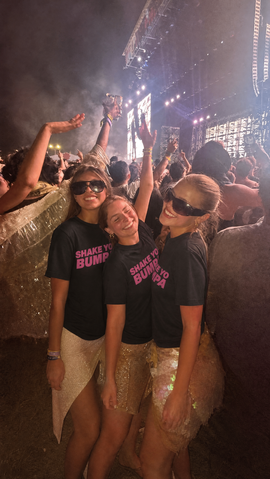 Drie vrouwen in Shake Ur Bumpa shirts bij een concert